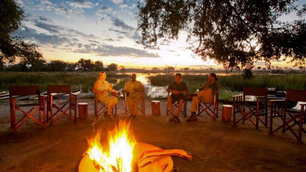 people-sitting-around-a-fire-at-pom-pom-camp