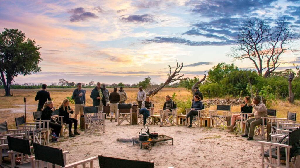 people-sitting-around-a-fire-at-splash-camp-in-the-early-morning